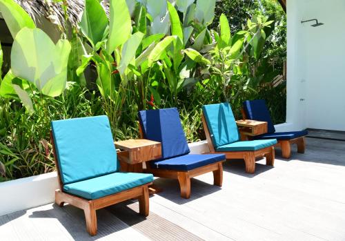 four blue chairs sitting in a row on a patio at Villa Pura Vida Apartments Siargao in General Luna