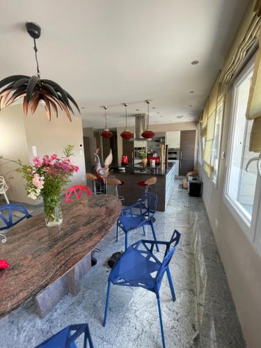 ein Esszimmer mit einem Holztisch und blauen Stühlen in der Unterkunft Chambre superbe à découvrir au cœur des Vosges uni in La Celle-sous-Gouzon