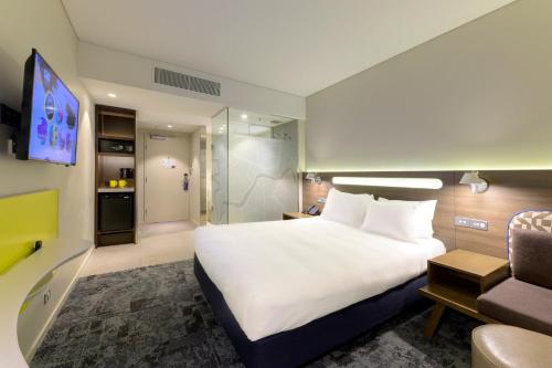 a hotel room with a large bed and a tv at Holiday Inn Express Brisbane Central by IHG in Brisbane
