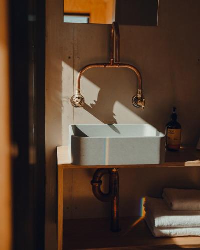 a sink in a bathroom with a copper piping at Beach Front Off-Grid Cabin on Kangaroo Island - Xanthe in Antechamber Bay