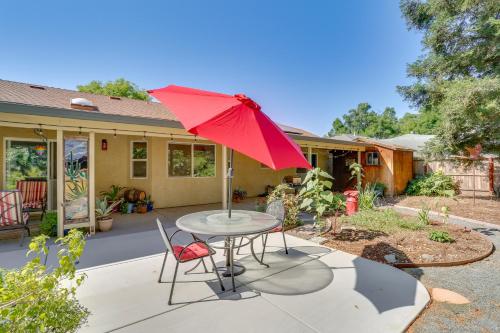 a table with a red umbrella on a patio at about 3 Mi to Dtwn and Chico State NorCal Escape! in Chico