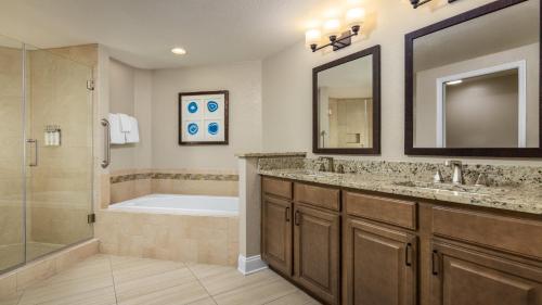 a bathroom with a tub and a sink and a shower at Holiday Inn Club Vacations At Orange Lake Resort in Orlando