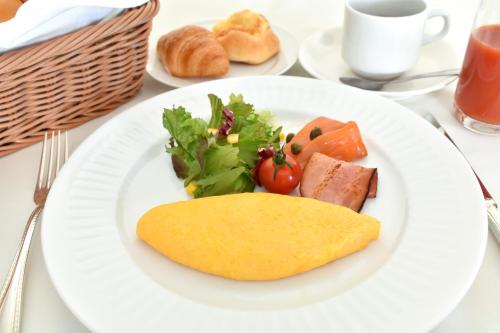 a white plate with food on a table at Odysis Suites Osaka Airport Hotel in Izumi-Sano