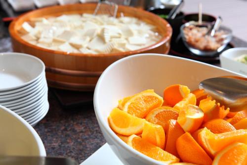 a bowl of orange slices on a counter with a dip at Odysis Suites Osaka Airport Hotel in Izumi-Sano
