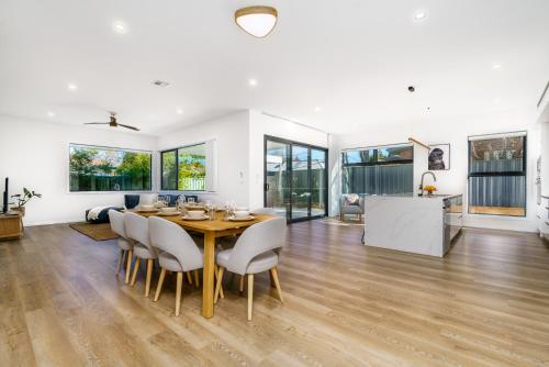 a dining room and living room with a table and chairs at New 4 bedroom city home with Tesla charger - Hosted by CanStay in Canberra