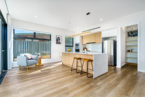 a kitchen with white walls and wooden floors at New 4 bedroom city home with Tesla charger - Hosted by CanStay in Canberra