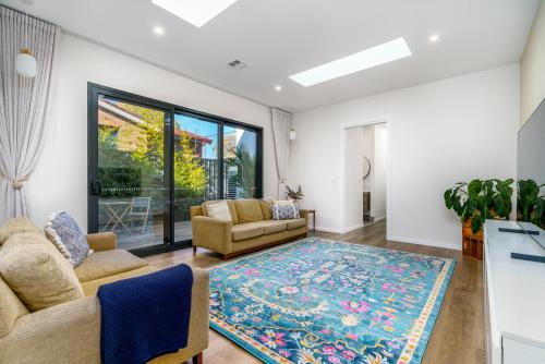 a living room with two couches and a rug at New 4 bedroom city home with Tesla charger - Hosted by CanStay in Canberra