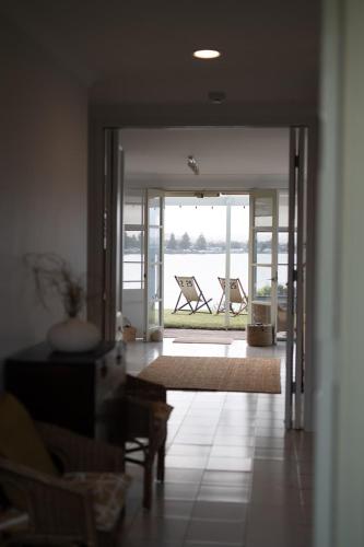 a living room with a door open to a patio at Whalers Rest Ocean front Whale watching in Encounter Bay