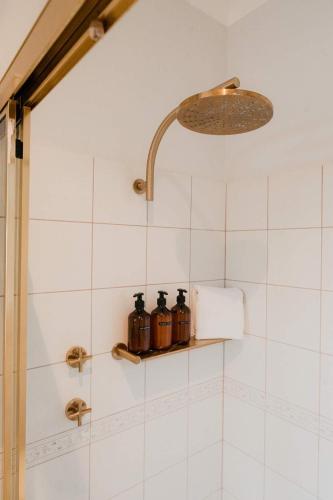 a shower with three bottles on a shelf in a bathroom at Whalers Rest Ocean front Whale watching in Encounter Bay