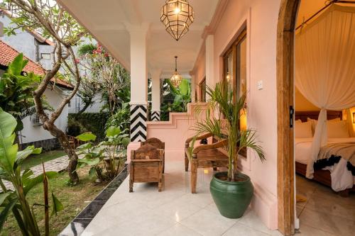 a room with a bed and a table with plants at Casa Coco in Nusa Lembongan