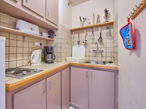 a small kitchen with white cabinets and a sink at Studio lumineux avec balcon exposé sud pour 2 personnes - FR-1-841-46 in Barbotan-les-Thermes