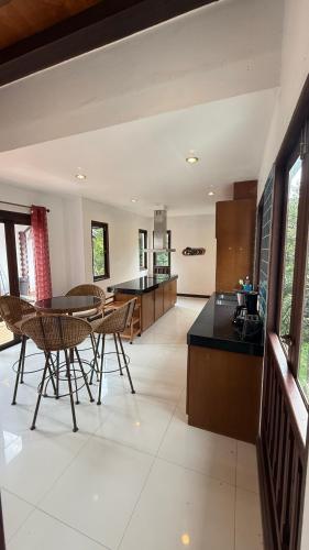 a kitchen with a table and chairs in a room at CM14 Beds & Private Pool in Mae Pim