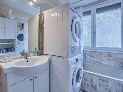 a white bathroom with a washing machine and a sink at T2 bis lumineux avec véranda, parking gratuit, wifi, proche nature - FR-1-841-33 in Barbotan-les-Thermes