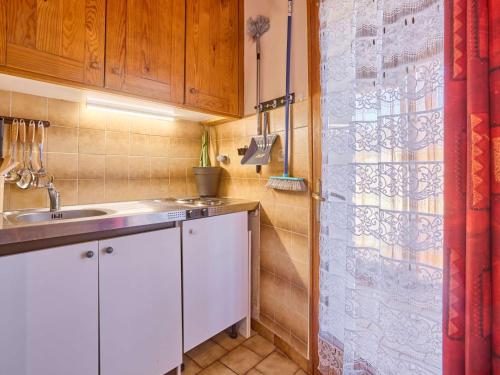 a small kitchen with a sink and a shower at T2 cosy avec véranda et parking, Wifi inclus - FR-1-841-14 in Barbotan-les-Thermes