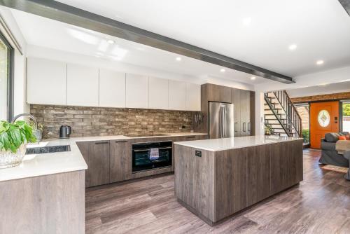 a kitchen with wooden cabinets and a counter top at 3BR Home near Canberra Hospital and Parliament - Hosted by CanStay in Harman