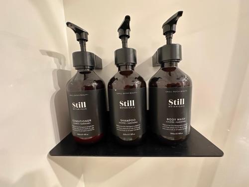 three bottles of sauce on a shelf in a refrigerator at Two Rivers Ohakune - Boutique Bed and Breakfast in Ohakune