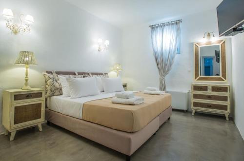 a bedroom with a bed with a mirror and a dresser at Luxury Paros Villa Master Villa Sea View Private Pool 3 Bdr Tserdakia in Kampos Paros