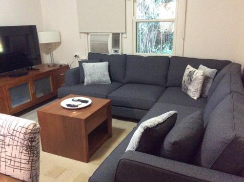 a living room with a blue couch and a coffee table at Rubicon Views Cottage in Acheron