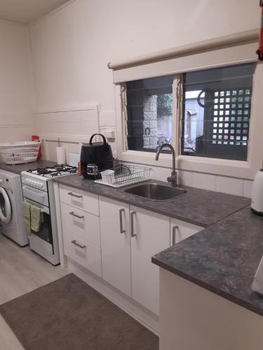 a kitchen with a sink and a stove at Rubicon Views Cottage in Acheron
