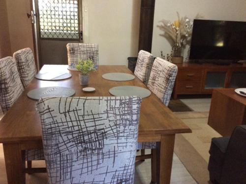 Rubicon Views Cottage في Acheron: طاولة غرفة طعام خشبية مع كراسي حولها