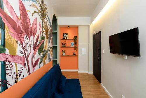 una sala de estar con un mural de flores en la pared en Loft no Centro do Rio de Janeiro, a 2 min do metrô Cinelândia, en Río de Janeiro