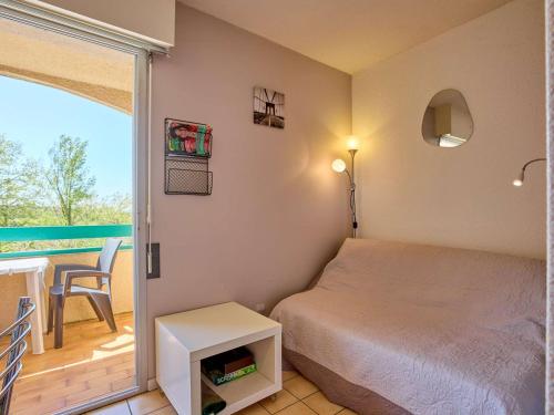 a bedroom with a bed and a balcony at T1 bis moderne avec balcon, Wifi, 2 pers - FR-1-841-78 in Barbotan-les-Thermes