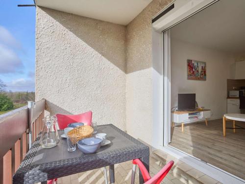 a table and chairs on a balcony with a view of a room at Spacieux T2 rénové, vue nature, balcon sud, Wifi, parking à Barbotan - FR-1-841-54 in Barbotan-les-Thermes