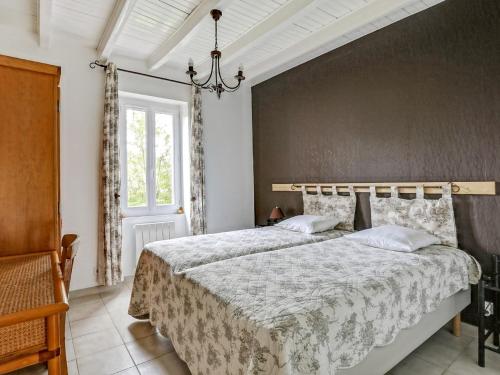 a bedroom with a large bed and a wall at Villa rénovée T3 près du lac et thermes - FR-1-841-60 in Cazaubon