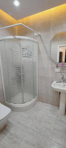 a bathroom with a shower and a toilet and a sink at فيلا بجوار سينزو مول in Hurghada