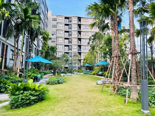 a park with palm trees and umbrellas in front of a building at Poolside Paradise, Nice pool view in Kathu
