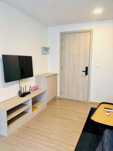 a living room with a flat screen tv and a door at Poolside Paradise, Nice pool view in Kathu