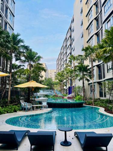 a swimming pool with chairs and umbrellas and palm trees at Poolside Paradise, Nice pool view in Kathu
