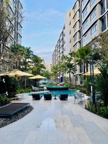 a courtyard with a pool and chairs and buildings at Poolside Paradise, Nice pool view in Kathu