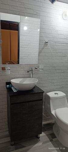 a bathroom with a sink and a toilet and a mirror at MeNTA GLAMPING in Sasaima