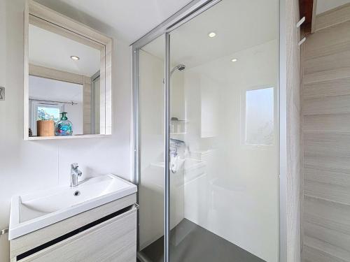 une salle de bain blanche avec un lavabo et une douche dans l'établissement Mobil-home spacieux 6 pers, 3 ch, 2 sdb, proche plage - FR-1-361A-98, à Jullouville