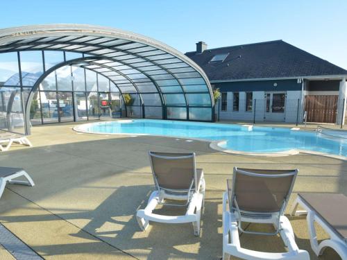 2 chaises assises en face d'une piscine dans l'établissement Mobil-home spacieux 6 pers, 3 ch, 2 sdb, proche plage - FR-1-361A-98, à Jullouville