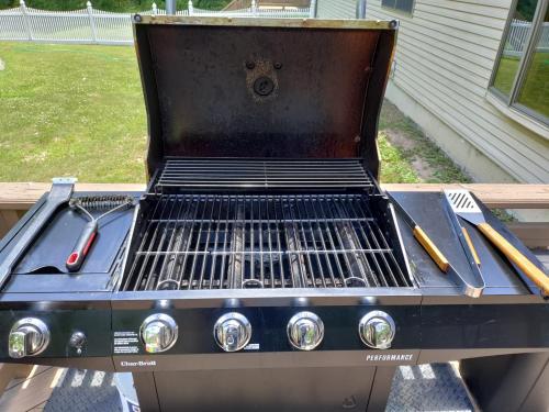 a grill with two utensils on top of it at Spacious House with a Pool in Glen Spey