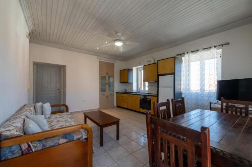 a living room with a dining room table and a kitchen at Mythos Suites-Aphrodite apartment in Methoni