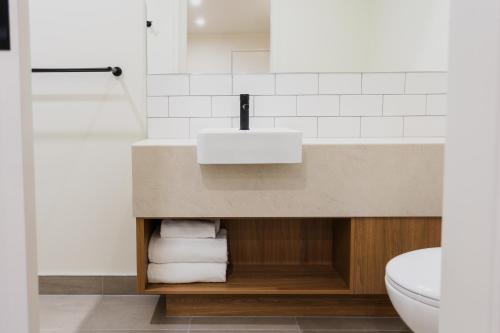a bathroom with a sink and a toilet at Coomera Lodge Hotel in Gold Coast