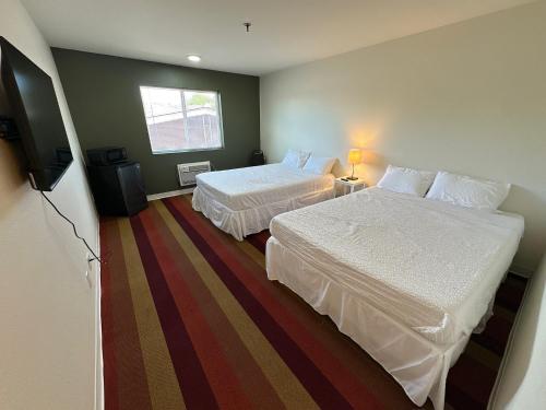a hotel room with two beds and a flat screen tv at The Ridge Hotel - Manitou Springs in Manitou Springs