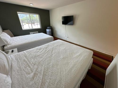 a hotel room with two beds and a television at The Ridge Hotel - Manitou Springs in Manitou Springs