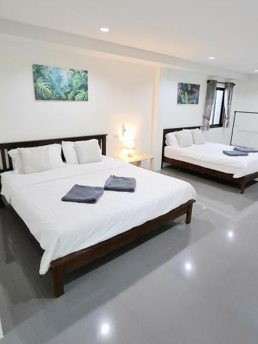 a bedroom with two beds with towels on them at Lanta Cozy House 02 in Ko Lanta