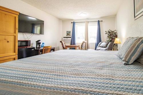 a bedroom with a large bed with a blue blanket at The Ridge Hotel - Manitou Springs in Manitou Springs