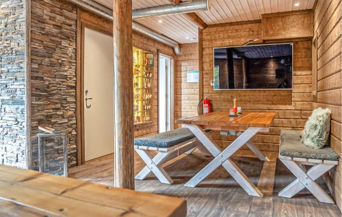 a dining room with a table and two stools at Nice Home In Arvidsjaur With Sauna in Arvidsjaur