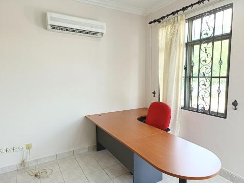 a desk with a red chair in a room with a window at Semi D 1-13 pax Klang Botanic Lengkuk Rhu 5R4B YSW Homes in Klang