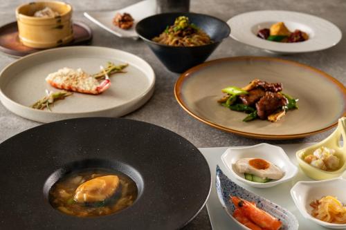 a table with plates of food on it at Art Hotel Narita in Narita