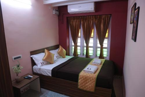 a small bedroom with a bed and a window at Tharavaadu by Le Apex in Puducherry