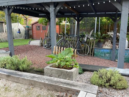 a garden with bikes parked under a pergola at Tiny House Le Poulailler in Bousbecque