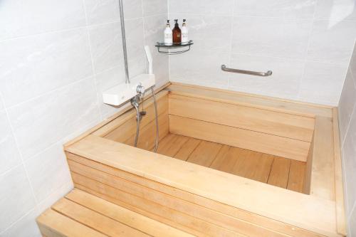a bathroom with a shower with a wooden floor at Mungang Hot Springs Hotel in Chungju