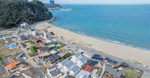 an aerial view of a beach with houses and the ocean at Gangneung Terramomum in Gangneung